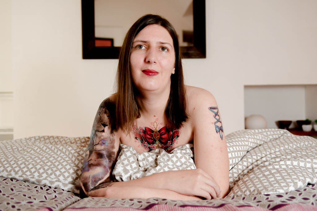 Femme tatouée allongée sur un lit