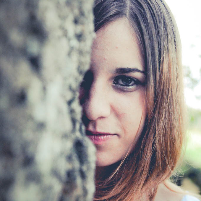 Portrait d'un visage apparaissant derrière un menhir